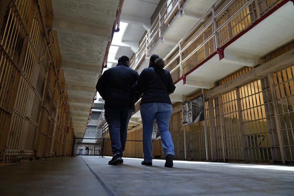 A couple walks through the main cell house on Alcatraz Island in San Francisco, Monday, March 15, 2021. The historic island prison was reopened to visitors Monday after being closed since December because of the coronavirus threat. Visitors were also able to tour the inside of the main cell house for the first time in a year.