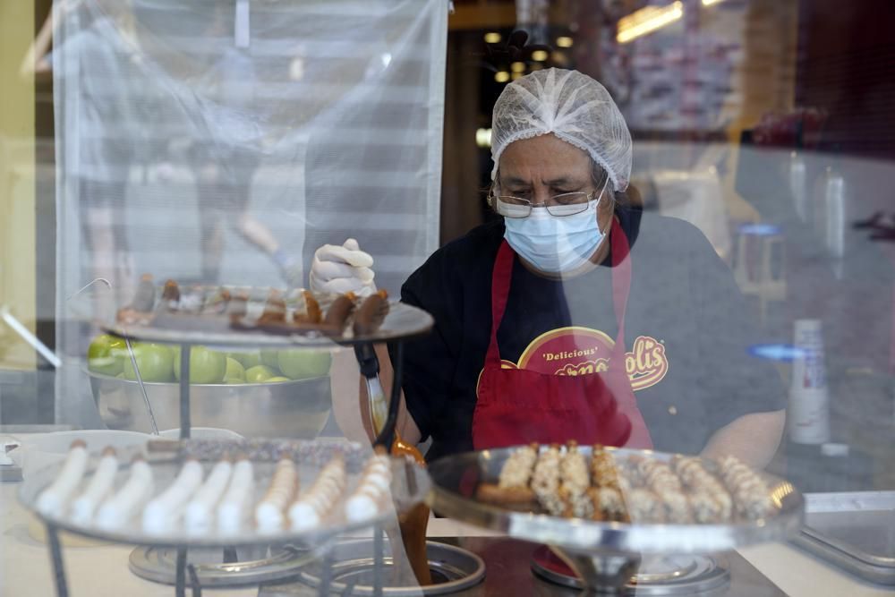 FILE - In this May 14, 2021, file photo, a worker wears a mask while prepares desserts at the Universal City Walk in Universal City, Calif. 
