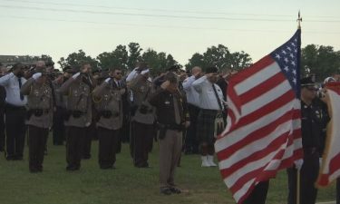 Law enforcement officers salute at the funeral of Baldwin County Sheriff's Deputy William "Bill" Smith