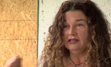 Laura Langone stands in front of a boarded-up portion of her Cape Coral