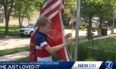 Sam Boje raises a flag for his neighbor in Omaha