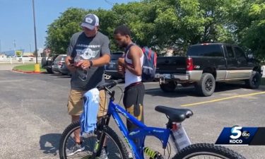 Michael Lynn (left) stands next to Donte Franklin and his new bicycle. The biker charity group My Riding Buddies Oklahoma and Bikers for Elves gave Franklin the bike after they saw Lynn's facebook post about Franklin's daily 17-mile walk to work.