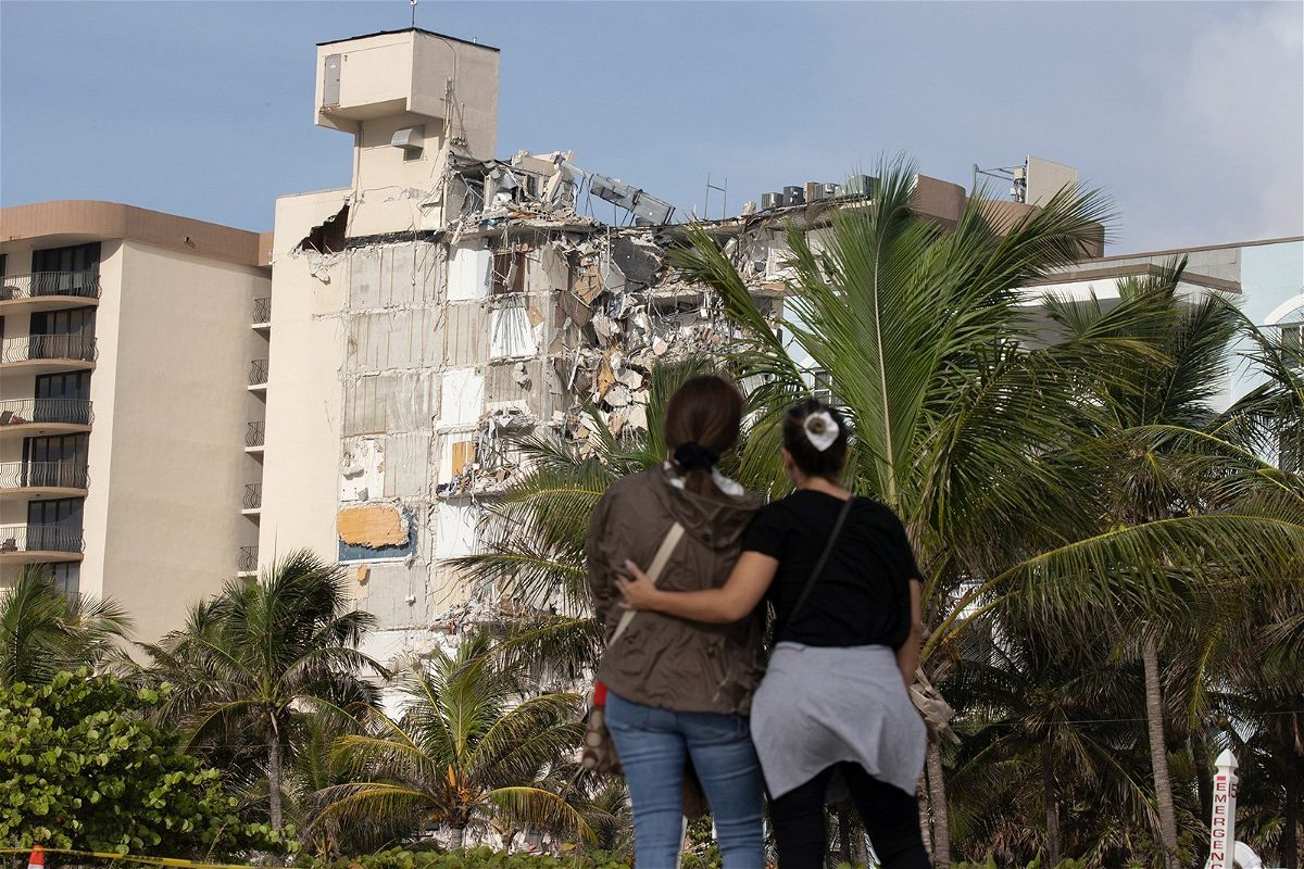 Maria Fernanda Martinez and Mariana Cordeiro look on as search and rescue operations continue at the site of the partially collapsed 12-story condo building on Friday in Surfside
