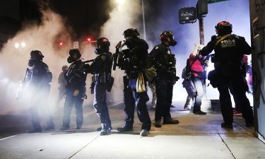 Police face off with protesters in front of the federal courthouse in downtown Portland on July 27