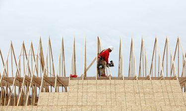 A contractor works on the roof of a house under construction at the Lennar Corp. Tree Tops community development in Lancaster