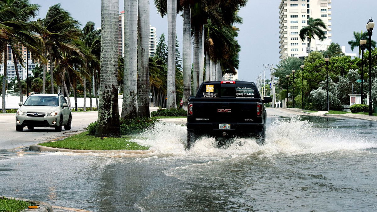 Cars slowly maneuver parts of Las Olas, flooded by king tides, in low-lying areas caused by the close proximity of the moon and exacerbated by inclement weather conditions and rising sea levels, Tuesday afternoon, Sept. 3, 2019 in Fort Lauderdale, Fla. as Hurricane Dorian churns in the Atlantic Ocean. 