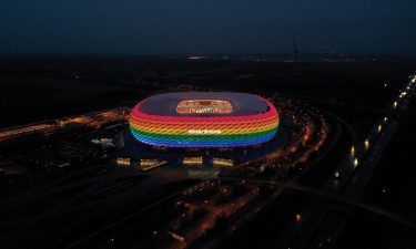 A drone image shows the Allianz Arena soccer stadium illuminated in rainbow colours during the Bundesliga match between FC Bayern Muenchen and TSG Hoffenheim on January 30 in Munich