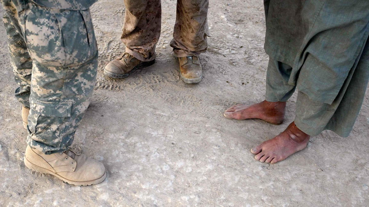 Senators introduced legislation to improve Afghan special immigrant visa program to ensure that Afghan interpreters who helped the US are protected once US troops fully withdraw from Afghanistan. Pictured, a U.S. Marine talks through his interpreter on July 6, 2009 in  Afghanistan.