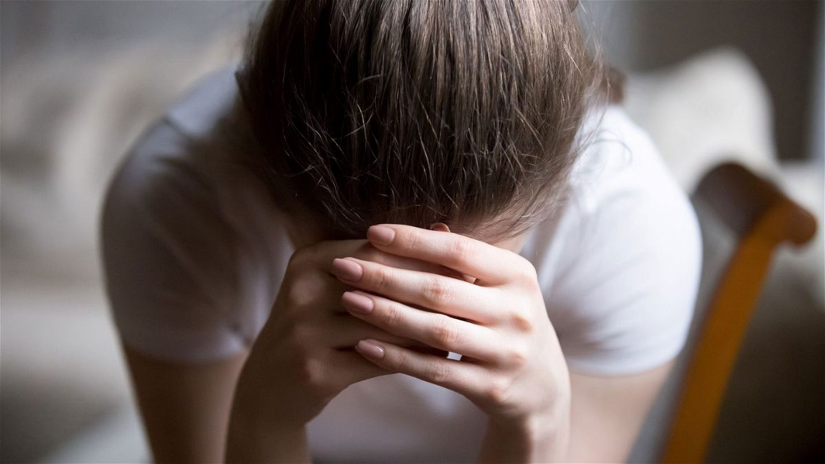 Close up image shows a woman sitting on chair crying at home. The United States saw a significant rise in suspected suicide attempts among teen girls during the pandemic, a new study from the US Centers for Disease Control and Prevention finds.