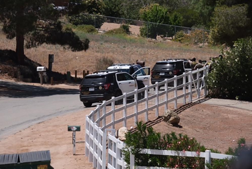 Police vehicles appear on the scene of a fire near a home in Acton, Calif. on Tuesday, June 1, 2021. Authorities say there's been a shooting at a Los Angeles County Fire Department station. Fire Department Supervisor Leslie Lua said paramedics responded to reports of gunshots at Fire Station 81, about 45 miles (72 kilometers) north of Los Angeles. The home on fire is about 10 miles (16 kilometers) east of the station, and there's a heavy police presence, but it's unclear if it's connected to the shooting and authorities didn't immediately have more information. 