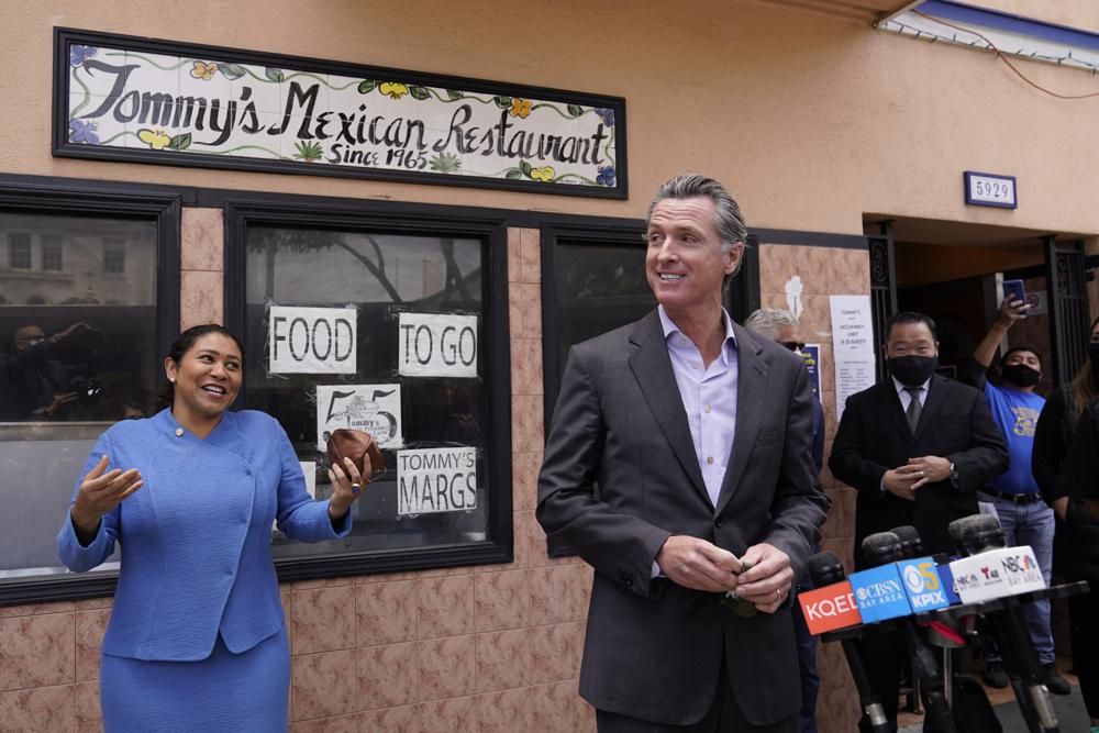 California Gov. Gavin Newsom prepares to speak at a news conference about relief for restaurants as San Francisco Mayor London Breed laughs and looks on outside Tommy's Mexican Restaurant in San Francisco, on Thursday, June 3, 2021. The governor offered his support for the extension and expansion of outdoor dining and takeout cocktails. 