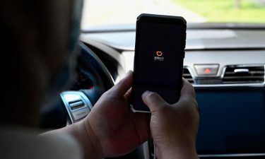A driver opens the Didi Chuxing ride-hailing app on his smartphone in Beijing on July 2. The Cyberspace Administration of China on July 4 banned Didi from app stores after saying it posed a cybersecurity risk for customers.