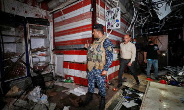 Iraqis inspect the site of an explosion at a popular market in eastern Baghdad on July 19.