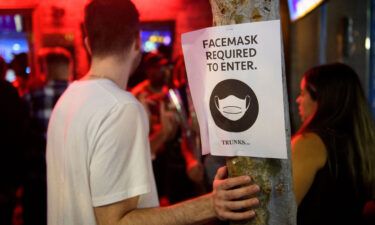 Face mask signage is displayed outside the Trunks bar after midnight early Sunday morning in West Hollywood