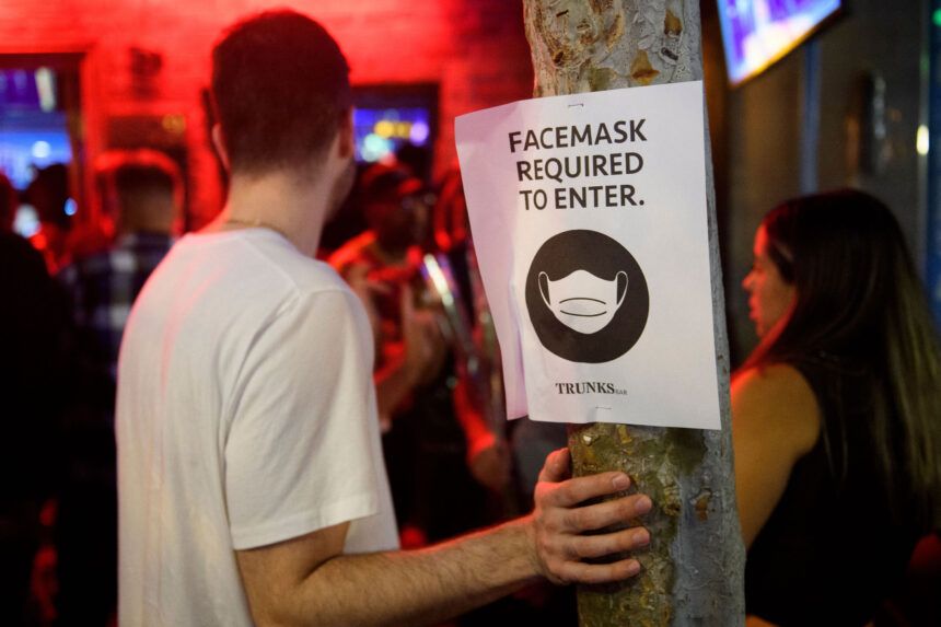 Face mask signage is displayed outside the Trunks bar after midnight early Sunday morning in West Hollywood