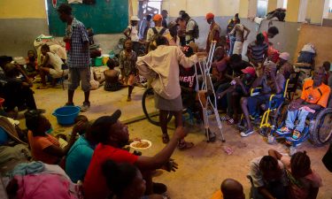 A group of blind and disabled people eat at a refuge for displaced persons after armed gangs set their homes on fire in Port-au-Prince on June 24.