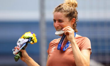 Swiss cyclist Marlen Reusser poses for a photograph and bites her silver medal after the women's individual time trial.