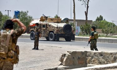 Afghan security personnel stand guard as Afghan security forces fight the Taliban in Kandahar on July 9.