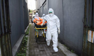 Health workers remove the body of a Covid-19 victim who died while isolating at home in Indonesia on July 14.