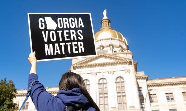 Demonstrators stand outside of the Georgia Capitol building