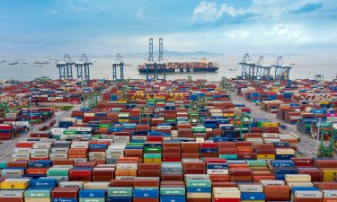 An aerial view is shown of shipping containers sitting stacked at Nansha Port