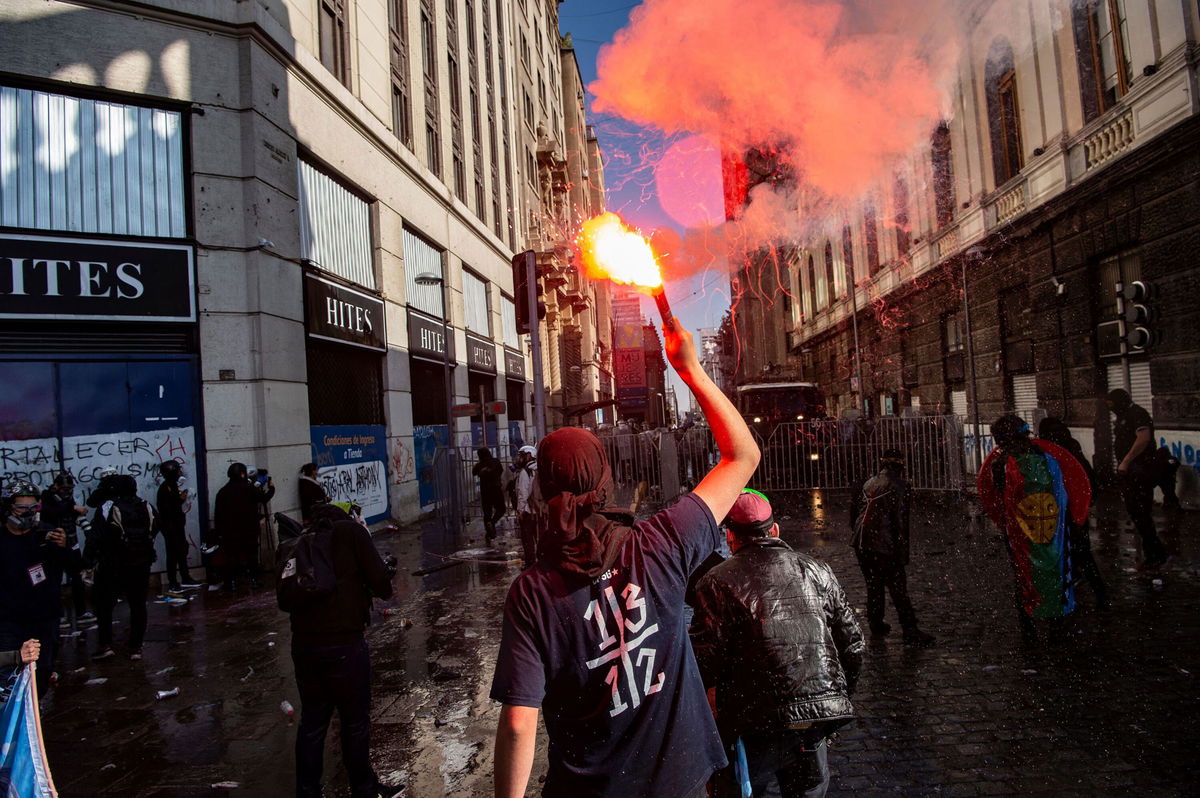 <i>Martin Bernetti/AFP/Getty Images</i><br/>Demonstrators are seen during clashes with riot police near the former Chilean National Congress where Constituent Assembly holds its first session