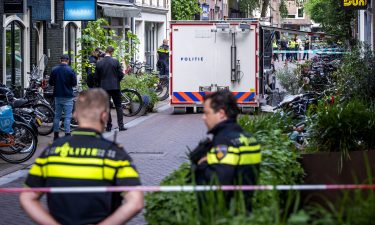 Police officers stand at the site of an attack on Dutch journalist Peter R. de Vries in Amsterdam on July 6.