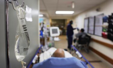 Patients rest in a hallway in an emergency room area.