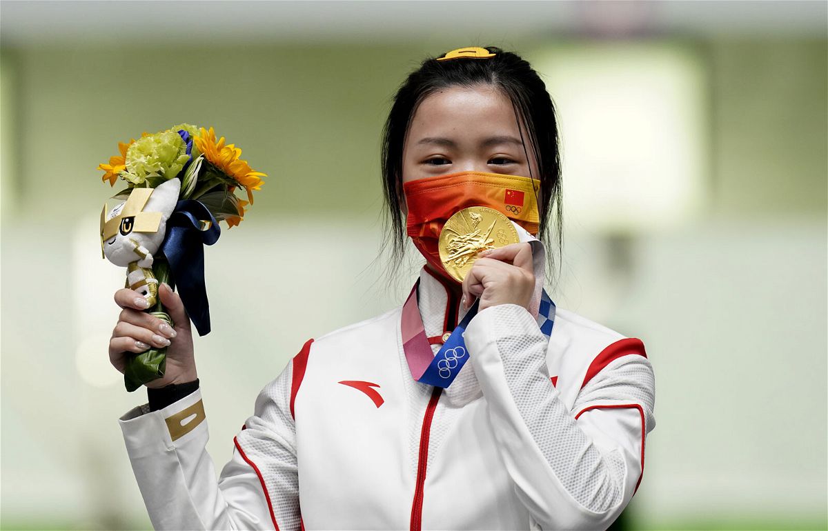 <i>Danny Lawson/PA Images/Getty Images</i><br/>China's Yang Qian celebrates with her gold medal after winning the 10m Air Rifle Women's Final on the first day of the Tokyo 2020 Olympic Games.