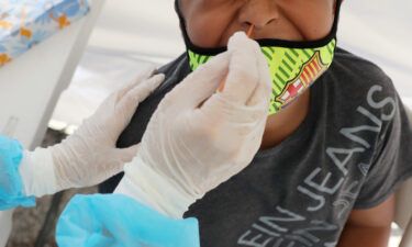 A boy receives a free Covid-19 test at a St. John's Well Child & Family Center mobile clinic set up outside Walker Temple AME Church in South Los Angeles amid the coronavirus pandemic on July 15