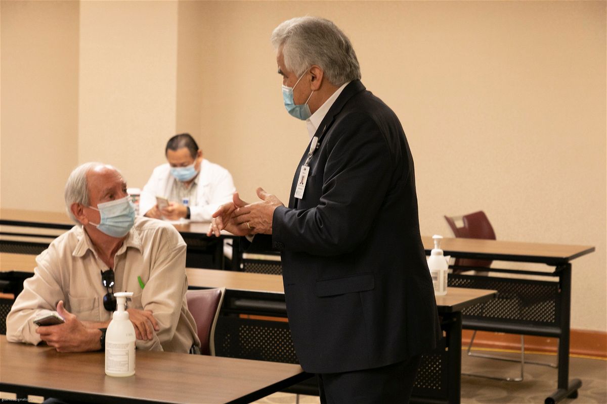 Pete Delgado speaks to an SVMHS employee at a vaccine clinic for staff members in January 2021