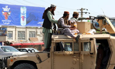 Taliban fighters stand guard in front of Kabul airport after they overthrew Afghanistan's Western-backed government.