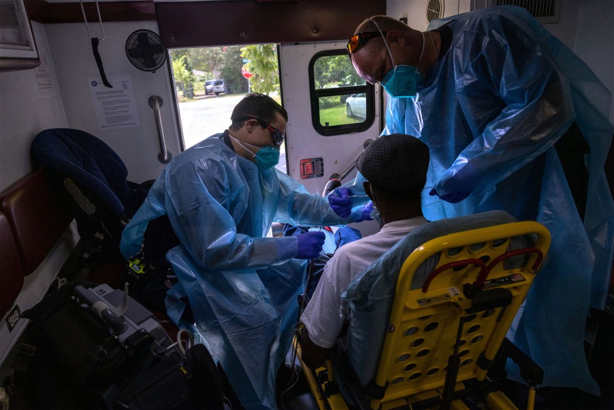 <i>John Moore/Getty Images</i><br/>Medics from the Houston Fire Department EMS prepare to transport a man with possible Covid-19 symptoms to a hospital on August 16.