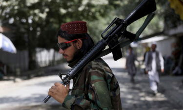 A Taliban fighter stands guard at a checkpoint in the Wazir Akbar Khan neighborhood in the city of Kabul