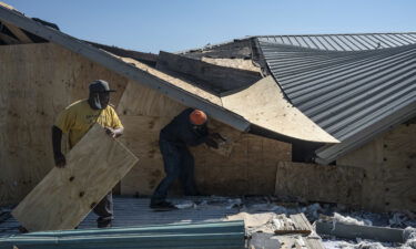 People work to seal the openings of a damaged bar in Lake Charles