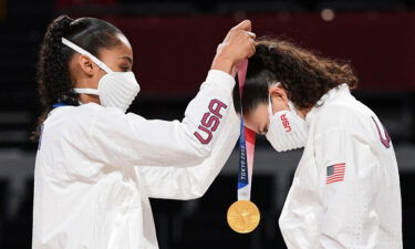 Team USA's Skylar Diggins (L) puts a gold medal on teammate Sue Bird during the medal ceremony for the women's basketball competition of the Tokyo 2020 Olympic Games on August 8.