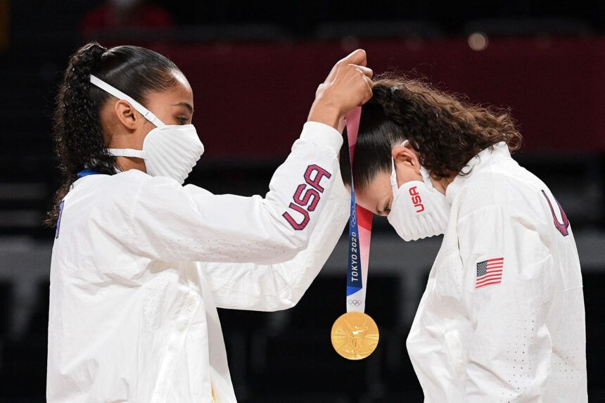 Team USA's Skylar Diggins (L) puts a gold medal on teammate Sue Bird during the medal ceremony for the women's basketball competition of the Tokyo 2020 Olympic Games on August 8.