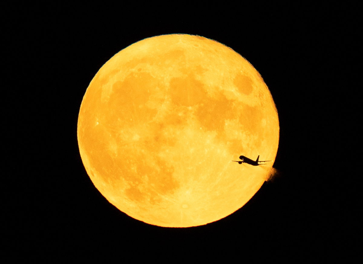 <i>Jeff Wheeler/Star Tribune/AP</i><br/>An aircraft passes in front of a Sturgeon moon (true blue moon) after takeoff from Minneapolis-St. Paul International Airport on August 3