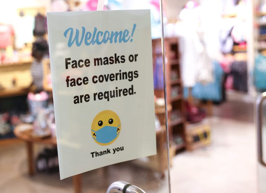 A sign requiring mask use is seen outside of a store in Union Station on July 30