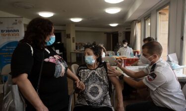 An Israeli woman receives a third coronavirus vaccine at a senior center in Jerusalem on Wednesday.