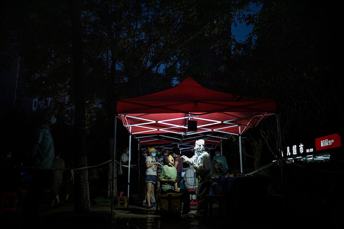 <i>Getty Images</i><br/>A medical worker takes samples during a mass COVID-19 test in a residential block on August 3