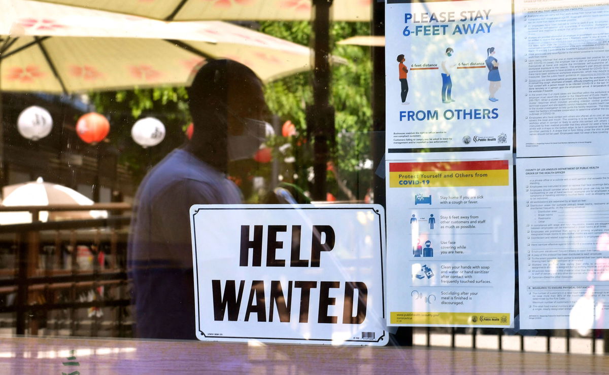 <i>Frederic J. Brown/AFP/Getty Images</i><br/>A 'Help Wanted' sign is posted beside Coronavirus safety guidelines in front of a restaurant in Los Angeles