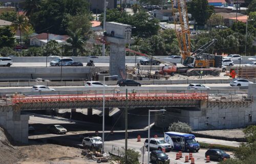 Construction workers build the "Signature Bridge