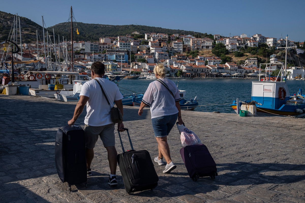 <i>Petros Giannakouris/AP</i><br/>People sit on a beach in Kokkari in front of a tavern on the eastern Aegean island of Samos