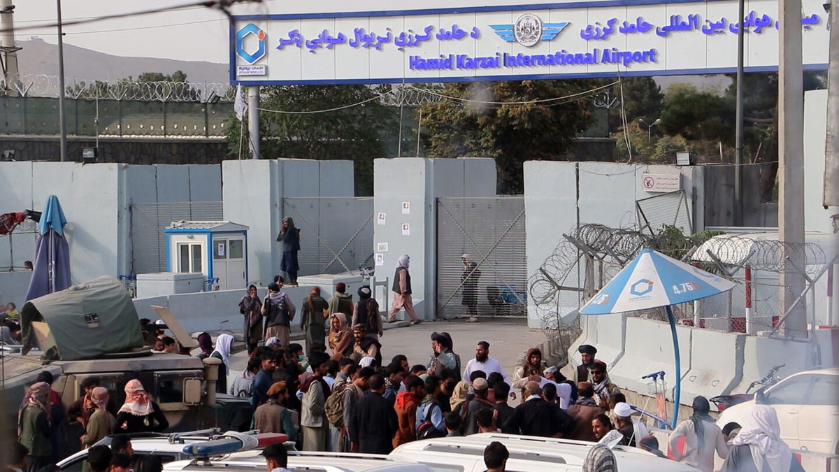 <i>Bashir Darwish/UPI/Shutterstock</i><br/>Taliban fighters stand guard as Afghans gather outside the Hamid Karzai International Airport to flee the country