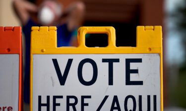 A poll observer stretches outside a polling station on Election Day