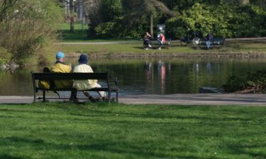The ultimate niksen: A couple sits on a bench in front of a pond at Wilhelminapark in Utrecht