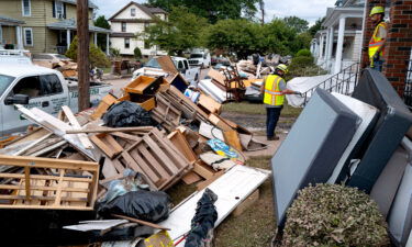 Utility workers work among debris from flood damage caused by the remnants of Hurricane Ida in Manville