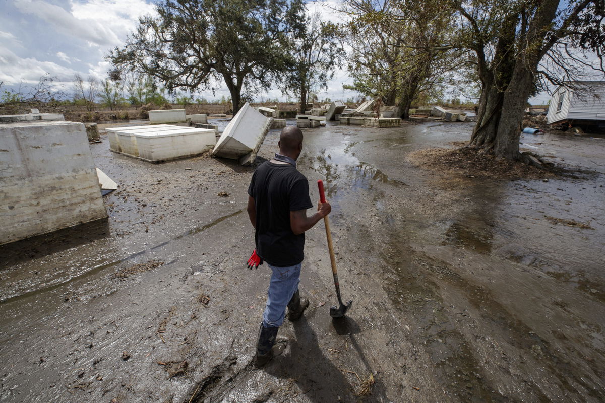 <i>David Grunfeld/The Times-Picayune/The New Orleans Advocate/AP</i><br/>An Ironton resident helps clean the cemetery on September 19.