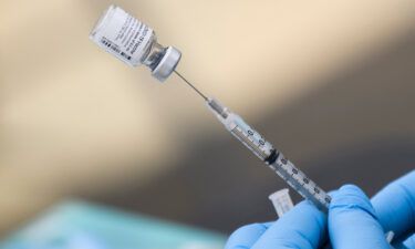 A syringe is filled with a first dose of the Pfizer Covid-19 vaccine at a mobile vaccination clinic during a back-to-school event offering school supplies
